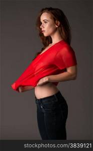 Pretty pale redhead in a red blouse and jeans