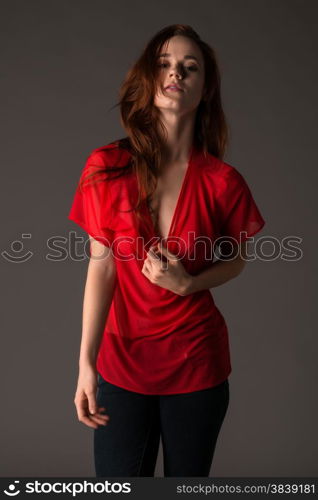 Pretty pale redhead in a red blouse and jeans