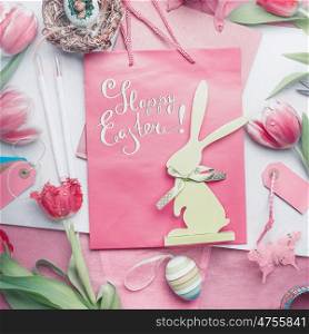 Pretty pastel Happy Easter card with lettering, tulips flowers, eggs and bunny decoration, top view