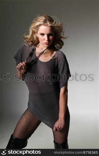 Pretty petite blonde in a gray sweater and fishnets