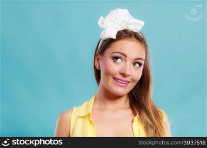 Pretty pin up girl with hairband bow. Attractive young retro woman posing in studio.