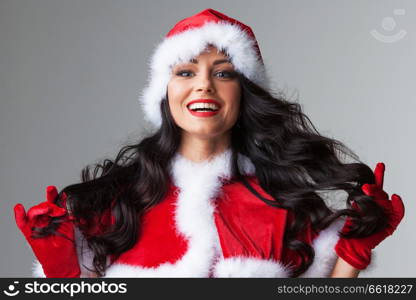 Pretty Pin-up style Santa girl in red clothes on gray background. Pin-up Santa girl