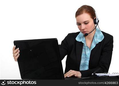 pretty receptionist with laptop and headset