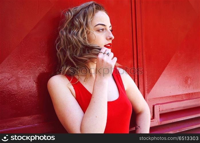 Pretty red woman against red wall