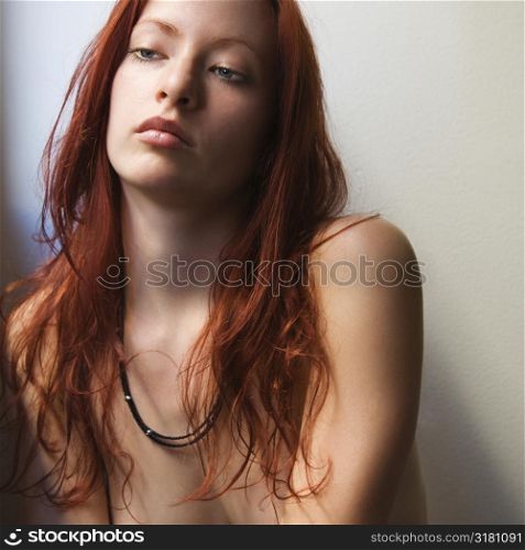 Pretty redhead bare young woman portrait against white background.