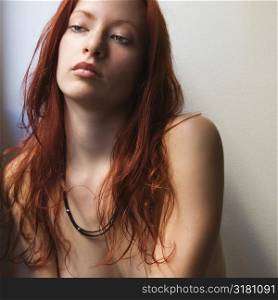 Pretty redhead bare young woman portrait against white background.