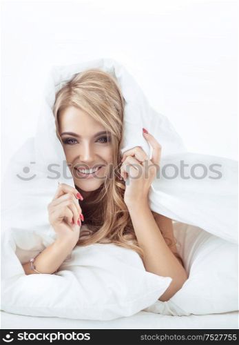 Pretty, sensual blond lady relaxing in the bright bedroom