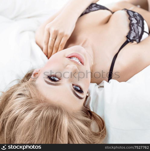 Pretty, sensual blond lady relaxing in the bright bedroom