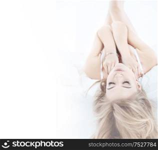 Pretty, sensual blond lady relaxing in the bright bedroom
