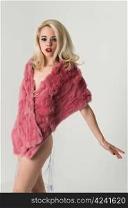 Pretty slender nude blonde in a fake fur coat