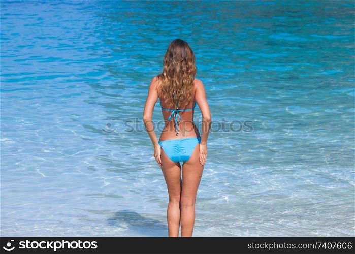 Pretty smiling girl in bikini at tropical sea beach. Pretty girl at the beach