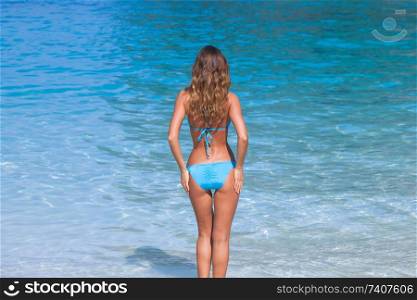Pretty smiling girl in bikini at tropical sea beach. Pretty girl at the beach