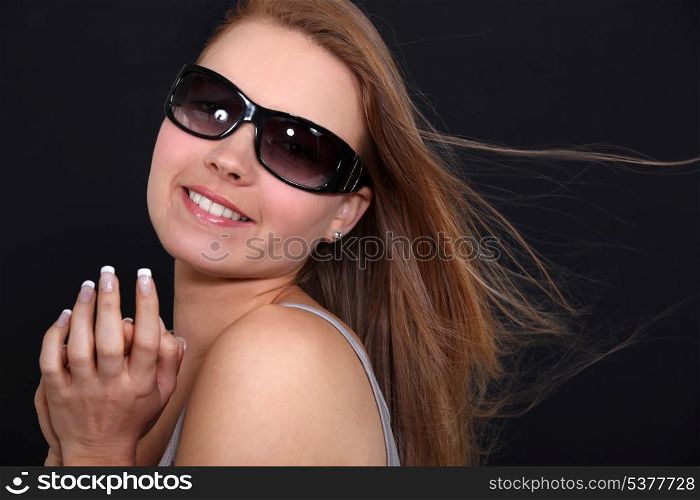 pretty smiling girl with sunglasses against black background