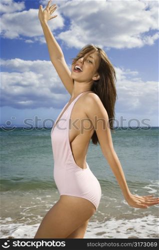 Pretty smiling young Caucasian woman in swimsuit having fun at beach in Maui Hawaii.