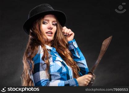 Pretty strong woman in hat holding machete.. Pretty gorgeous woman holding machete. Strong girl feminist wearing checked shirt and hat.