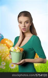 Pretty, surprised, girl in green dress with beautiful make up an she is holding bucket of easter eggs.