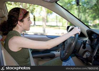 Pretty teen girl learning to drive a car.
