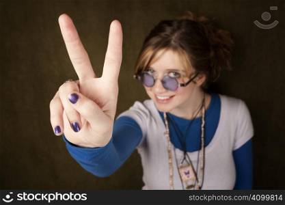 Pretty teen girl making a peace sign with her hand