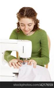 Pretty teen girl using a sewing machine. Isolated on white.