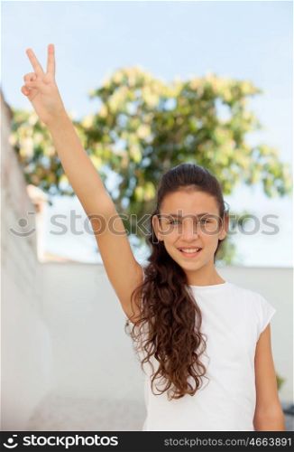 Pretty teenage girl doing symbol of victory outdoor