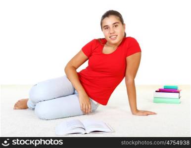 Pretty teenage girl sitting on th efloor with study books