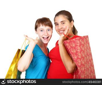 Pretty teenage girls with shopping bags in studio against white background