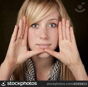 Pretty teenager framing her face with hands