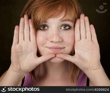 Pretty teenager framing her face with hands
