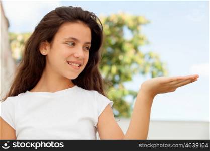 Pretty teenager girl looking her hand outdoor