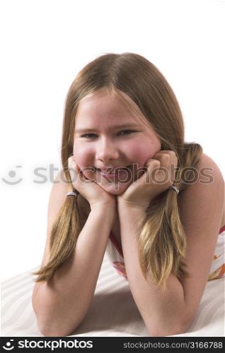 Pretty ten year old girl leaning on her hands while lying on the couch