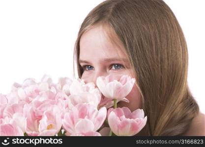 Pretty ten year old girl smelling the bouquet of pink tulips
