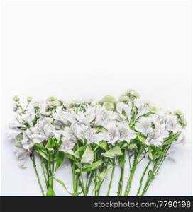 Pretty white and green flowers on white background, top view. Floral layout or card for wedding or other holidays with copy space