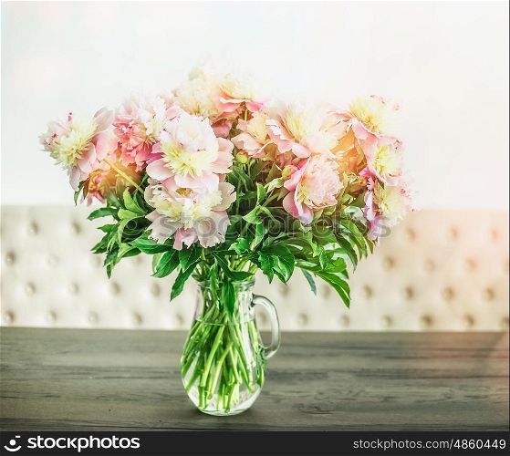 Pretty white pink peonies bouquet in glass vase on table, floral home interior design, front view