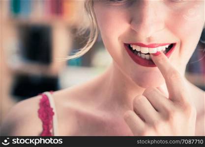 Pretty white woman with red sensual lipstick and colorful nail polish is looking into the mirror, cut out