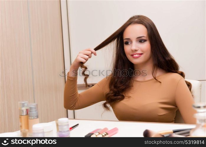Pretty woman doing her hair preparing for party