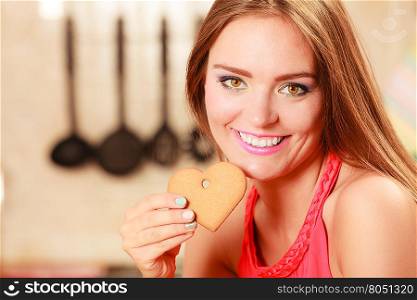Pretty woman eating biting gingerbread cookie.. Happy joyful woman biting heart shape gingerbread cookie. Pretty gorgeous woman relaxing while eating delicious biscuit food.