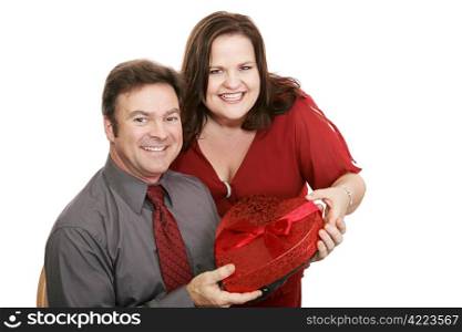 Pretty woman giving her husband a box of valentine chocolates. Isolated on white.