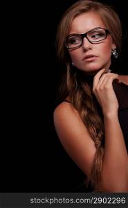Pretty woman giving suspicious look in glasses on black background