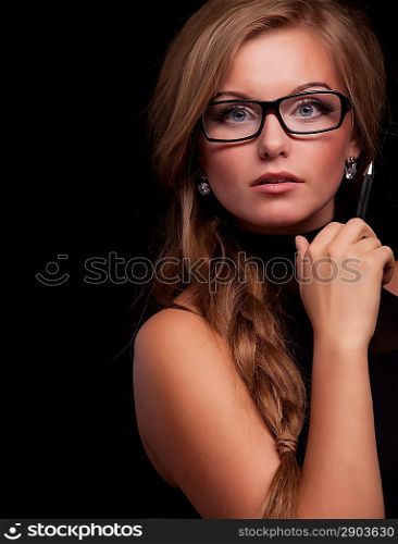 Pretty woman giving suspicious look in glasses on black background