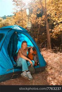 Pretty Woman Having Fun in the Forest in Sunny Day. Cute Female Sitting in the Tent. Happy Active Lifestyle.. Traveler Woman in the C&