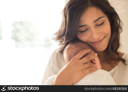 Pretty woman holding a newborn baby in her arms