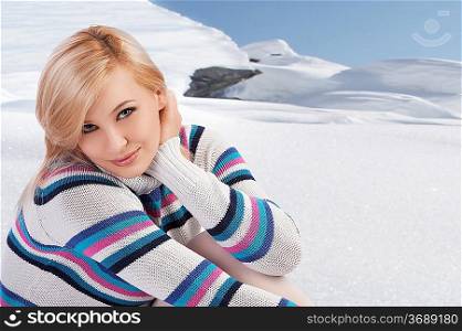 pretty woman in a beauty fashion shot wearing a colored warm and comfortable sweater looking at the camera against white background