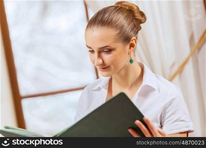 Pretty woman in restaurant. Image of pretty woman sitting at restaurant with menu in hands