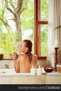 Pretty woman in the bathroom with an open window to the garden, enjoying peaceful day on the spa resort, beauty and health treatment