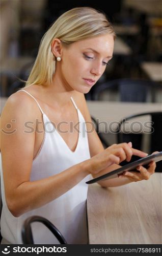 pretty woman in the restaurant using a tablet