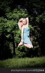 Pretty Woman Jumping High On The Nature Background