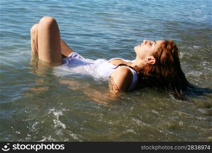 Pretty woman lying in the sea.