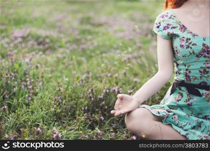 Pretty woman meditate in the park with flowers