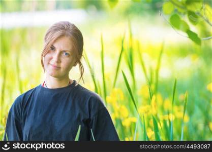 Pretty woman on the green field with yellow flowers