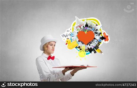 Pretty woman opening romantic book. Young woman in white cylinder and red bowtie with book in hands